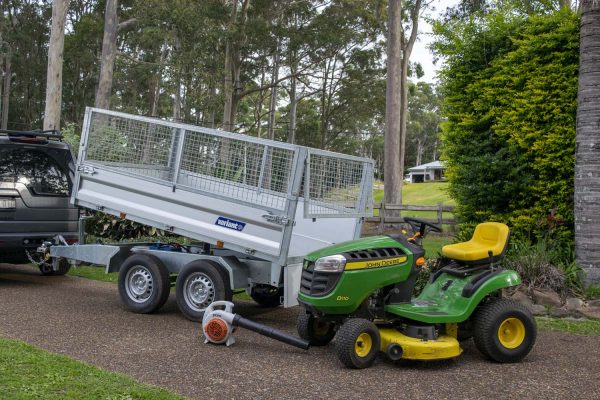 John Deere mower on Variant tipper trailer with ramps and cage sides - gardeners best tools.