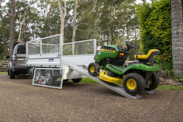 John Deere mower on Variant tipper trailer with ramps and cage sides - gardeners best tools.